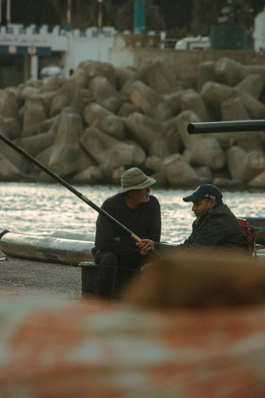 the two men are fishing in the shallow waters