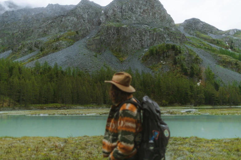 a man in plaid jacket walking next to water