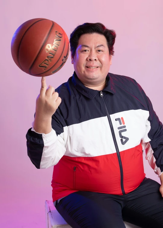 man with basketball sitting on top of a stool