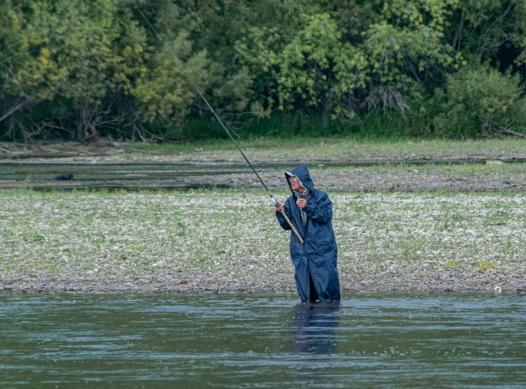 the fisherman is standing in the water fishing