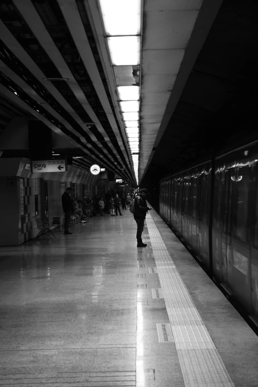 black and white po of people standing on a subway platform