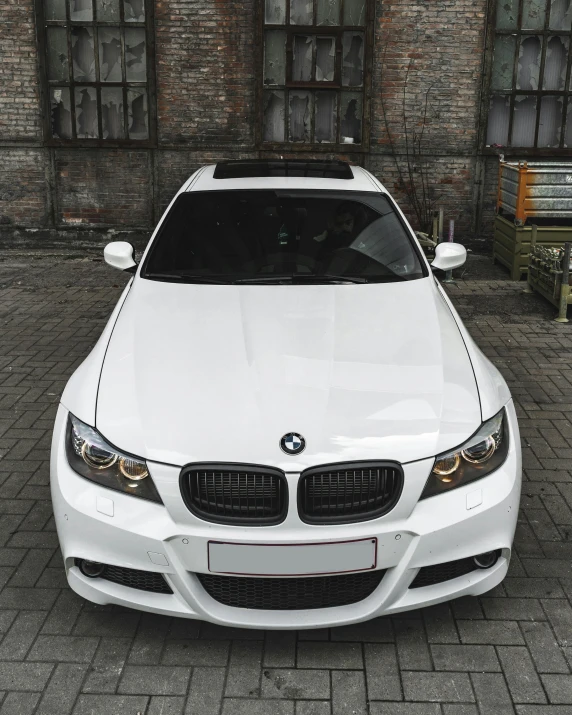 a white car is parked on a brick street