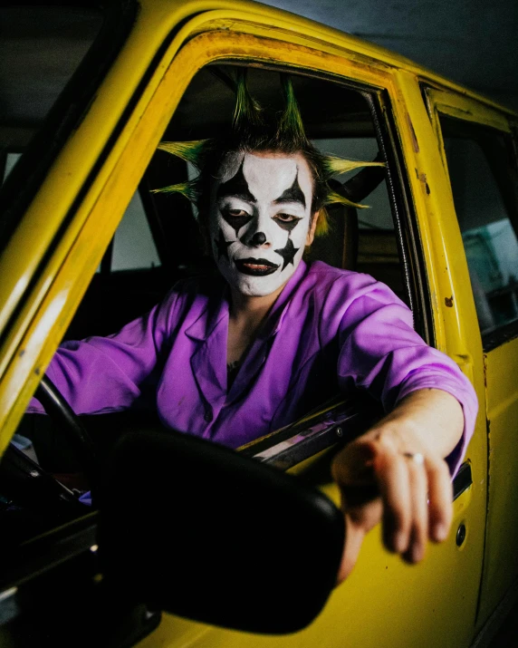 a person in a clown mask riding in a taxi