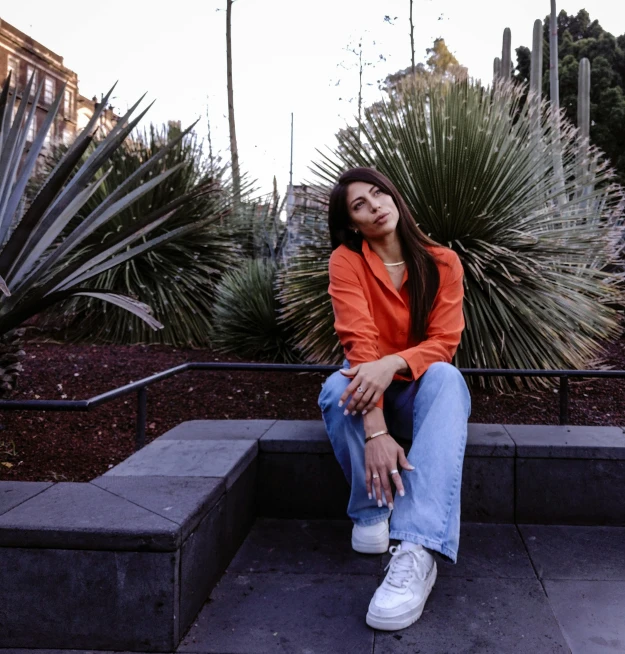 the woman in a orange top is sitting on the steps