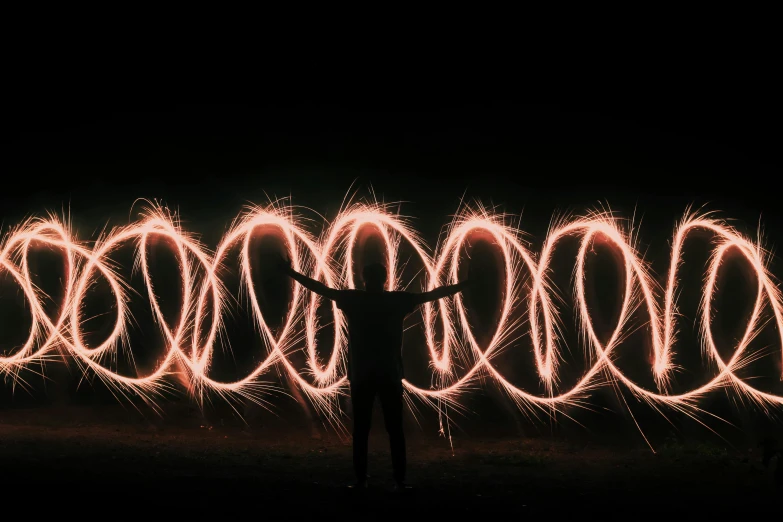 a silhouette of a person and the fireworks