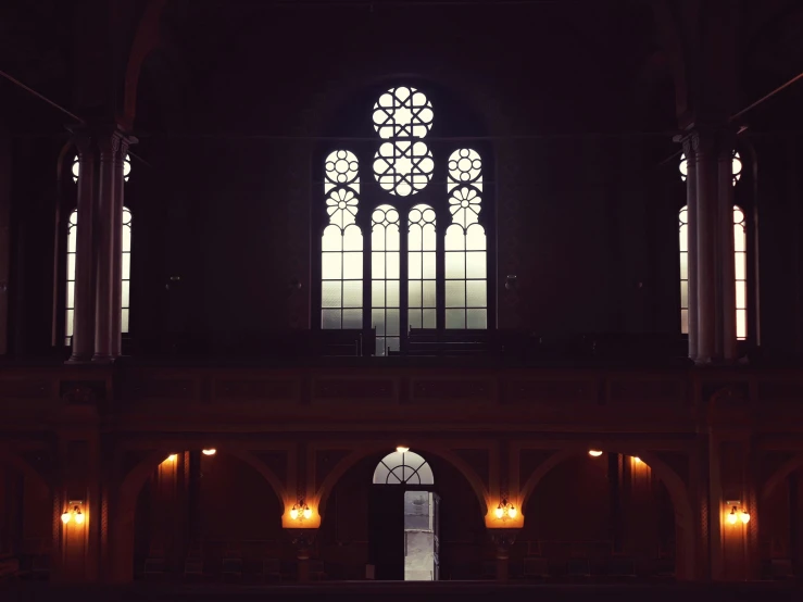 a large cathedral with a window and lit candles