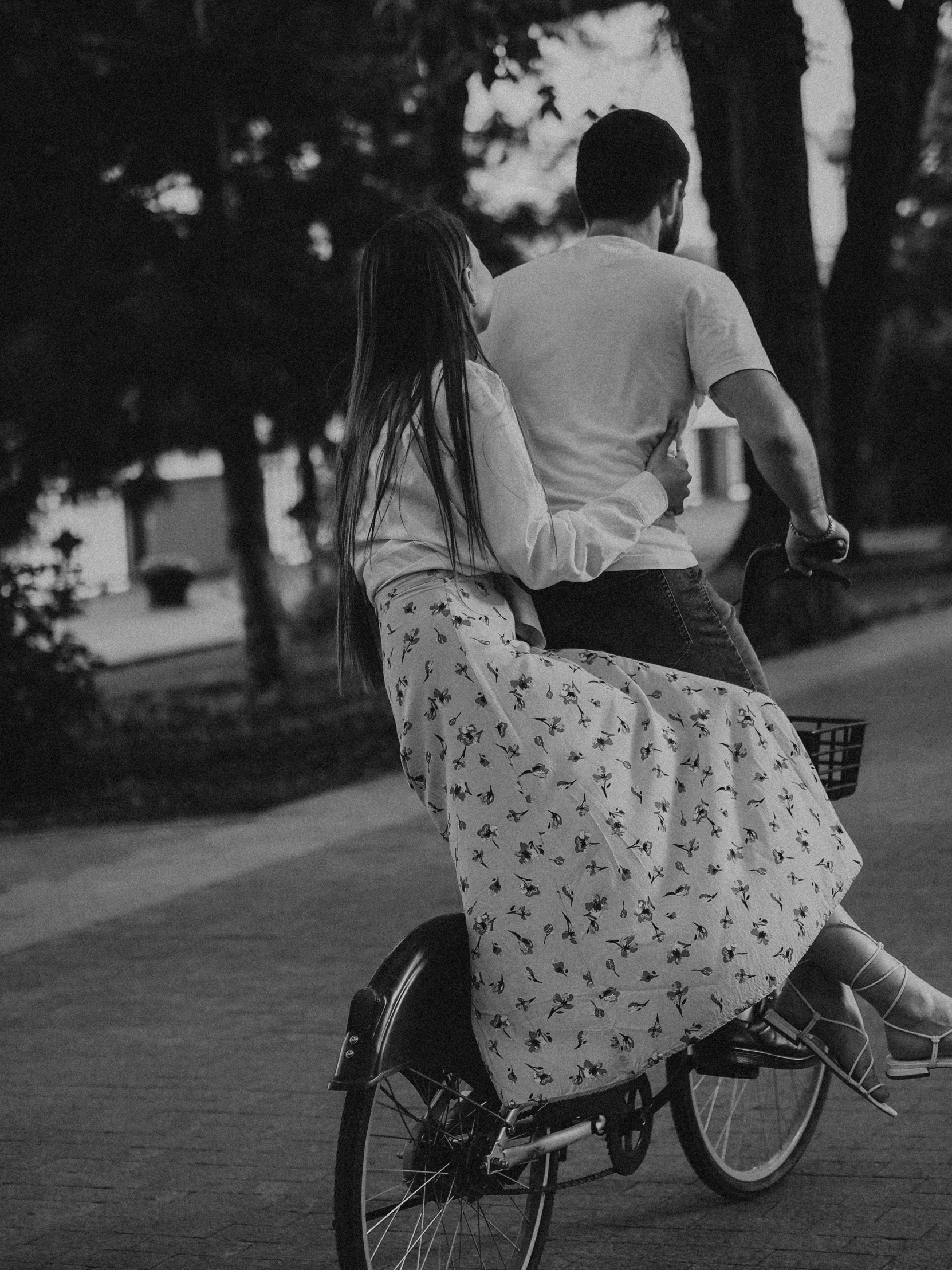 a man is sitting on the back of a bike, riding with a woman