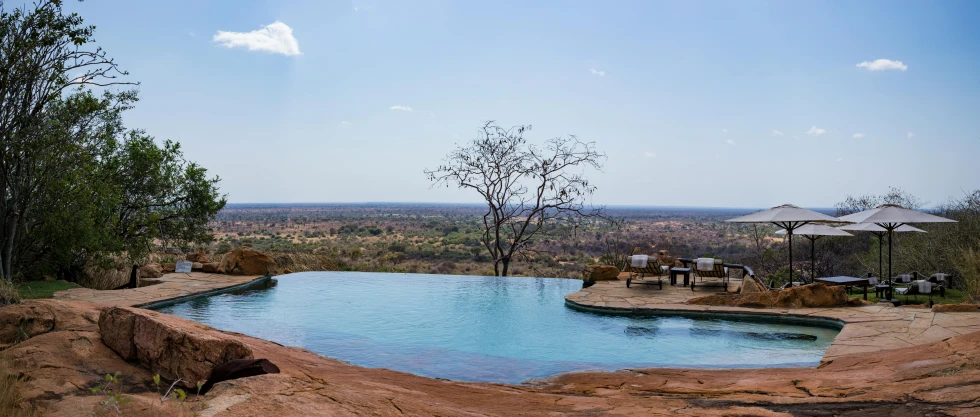 a pool sitting next to a large rock formation