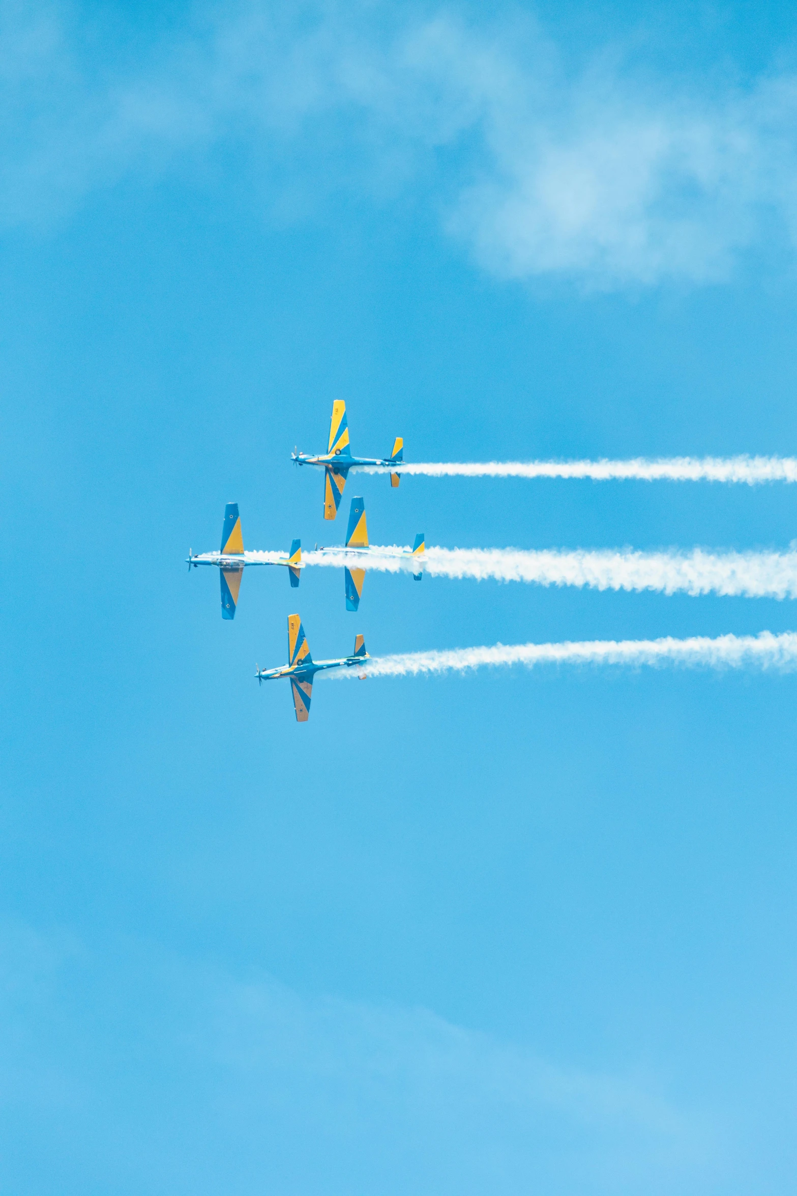 four airplanes leave smoke trails in the blue sky