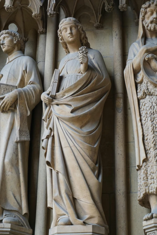 two statues on a building side next to each other