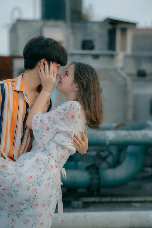 two people in front of a water tank kissing each other