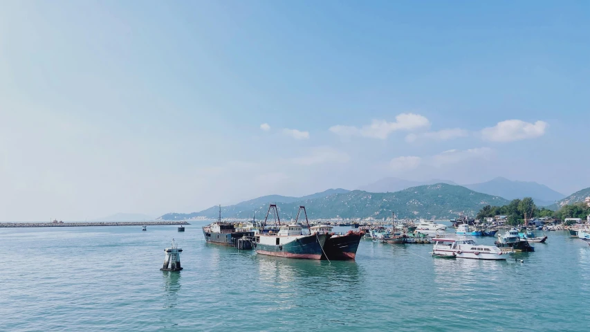 boats are in the ocean and on a hill in the background