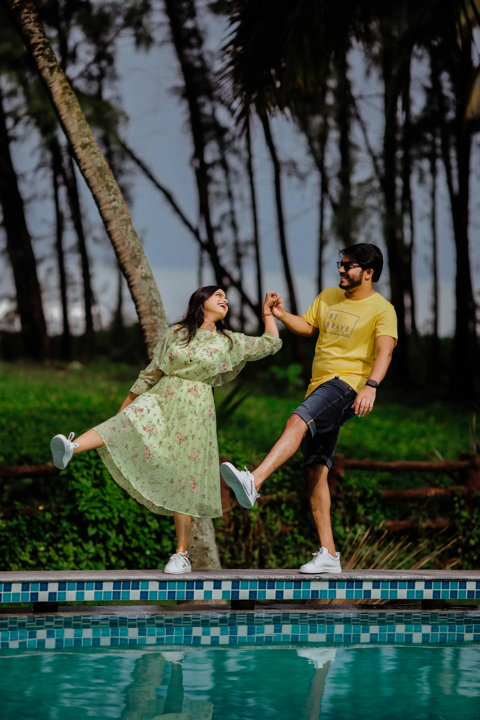 a couple jumping into a swimming pool, to each other