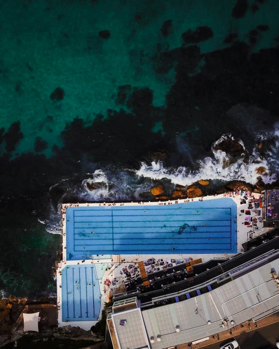 an aerial view shows a swimming pool and parking spaces on the ocean