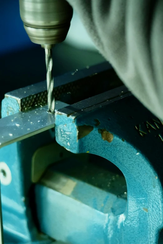 a person drilling an object on a machine