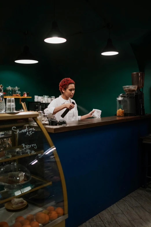 a woman sitting behind a counter working on a paper