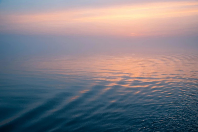 a very bright sky over some water at sunset