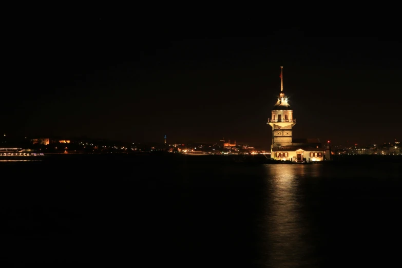 a lighthouse that is on the water at night