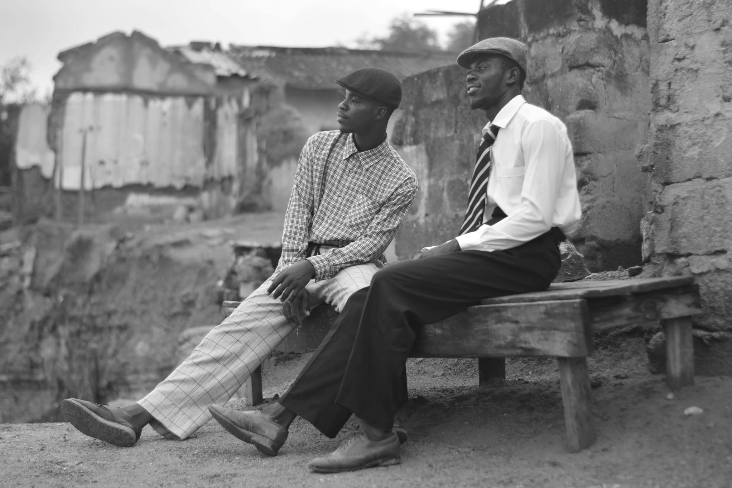 two people are sitting on a wooden bench