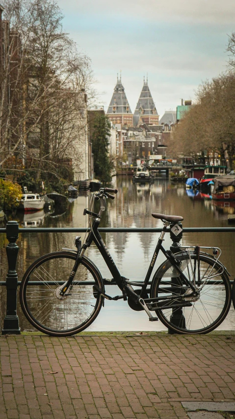 two bicycles parked by the water outside a building