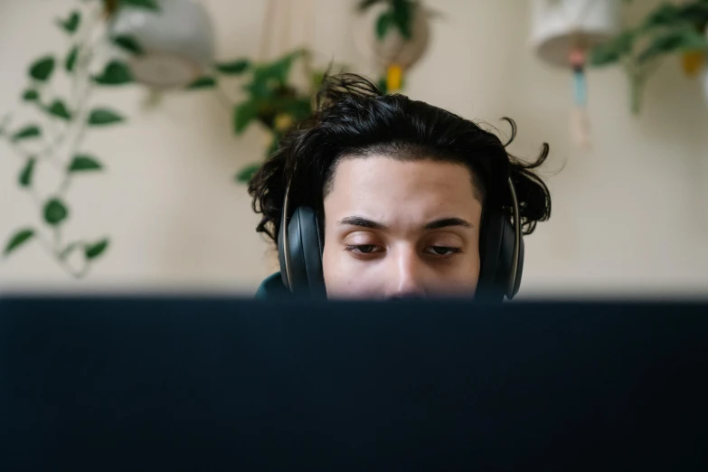 there is a man with headphones on looking at a computer screen