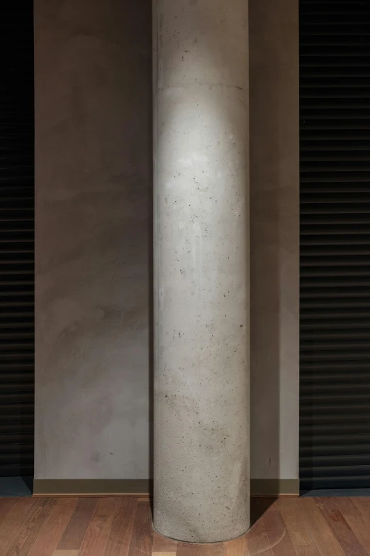 the front of a white pedestal lamp on a hard wood floor