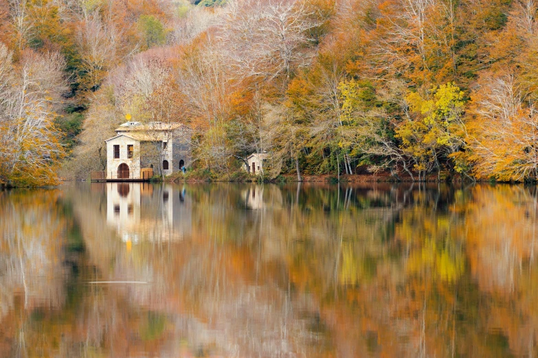 a small white building sits in front of some trees