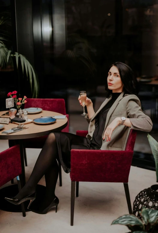 a woman holding a wine glass at a table