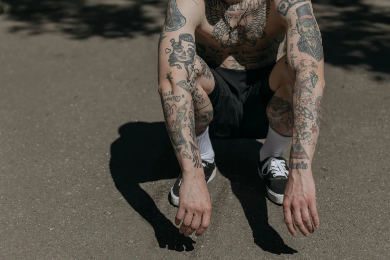 a person with a leg tattoo crouching down