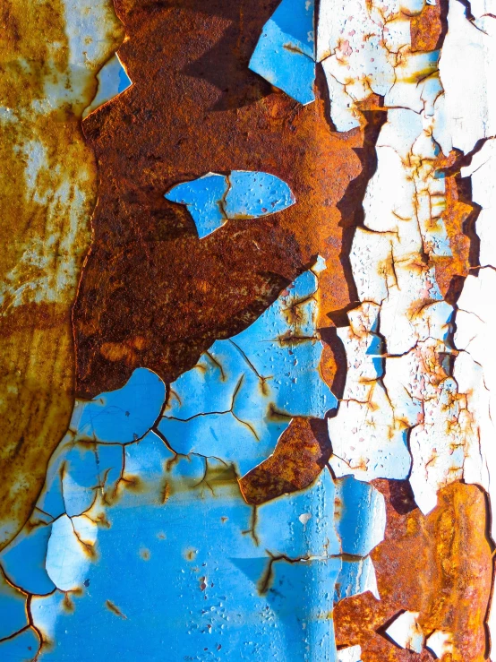 a rusted metal surface with blue and orange paint