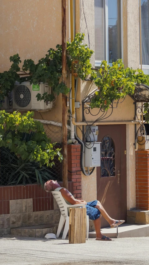 a person sitting on a chair next to a building