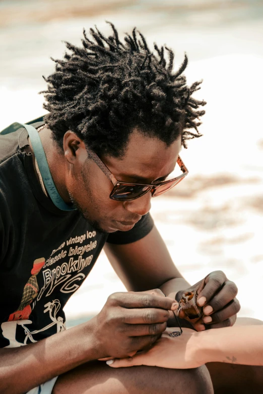 there is a man that is working on soing on the beach