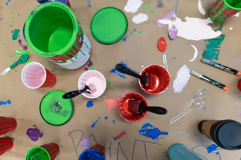 two buckets are next to a cup with different colors on it