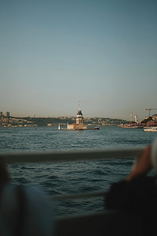 the lighthouse is near a river and a town