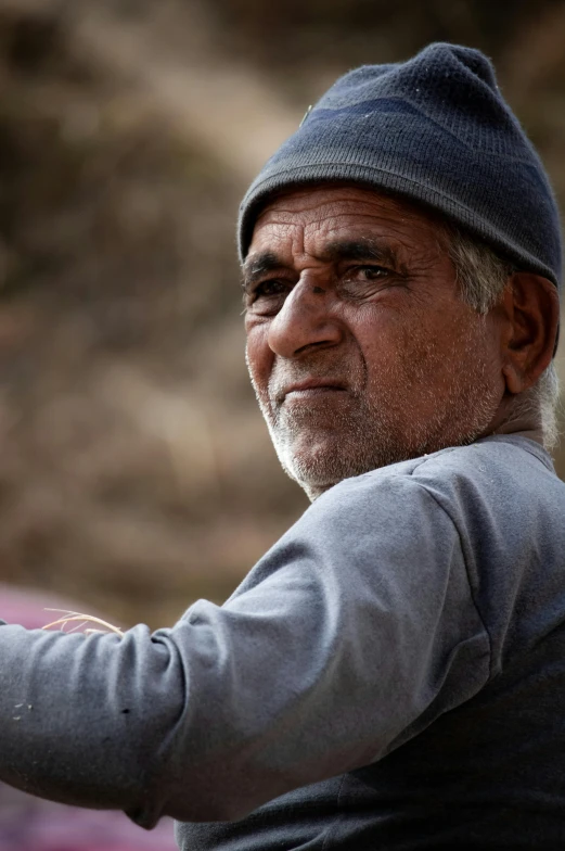 a man wearing a gray sweatshirt and a cap