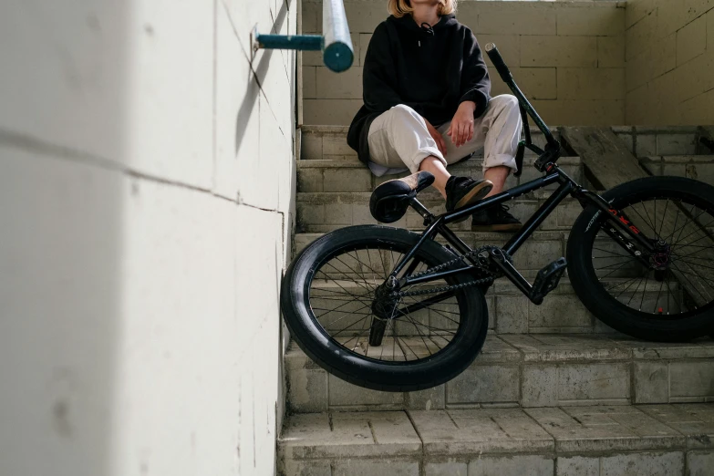 a man sitting on steps with a bike in front of him