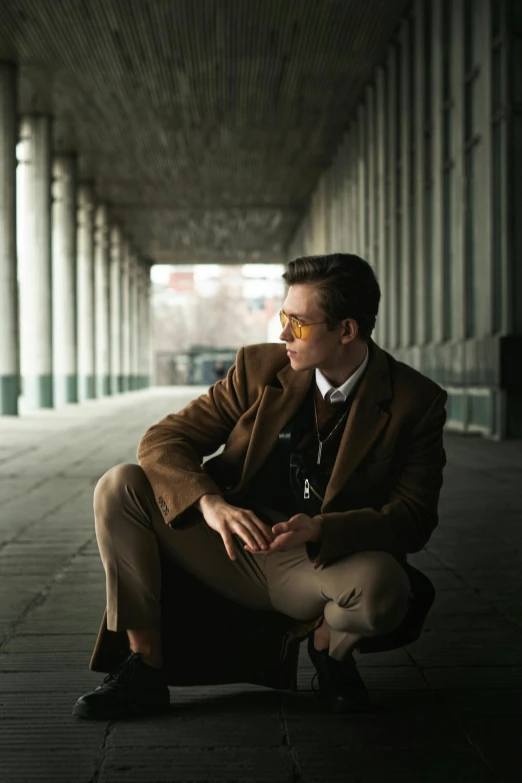 a man in a tan suit is kneeling on the floor