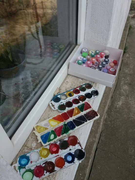 a window sill with a row of colored glass bottles behind it