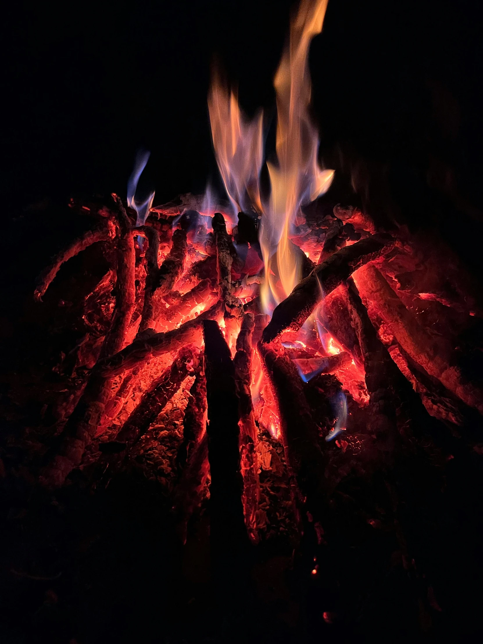 some sort of fire in the dark near some rocks