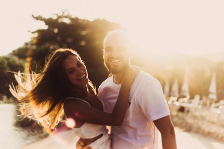 a man holds his lady on the back, while he smiles broadly