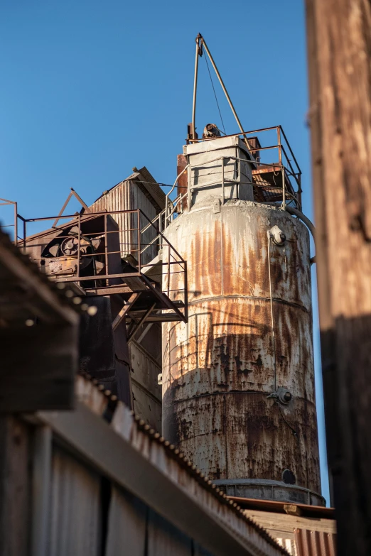 a large metal factory tower near a building