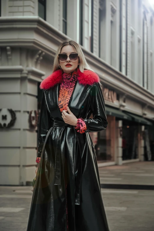 a young woman wearing a coat and sunglasses poses for the camera