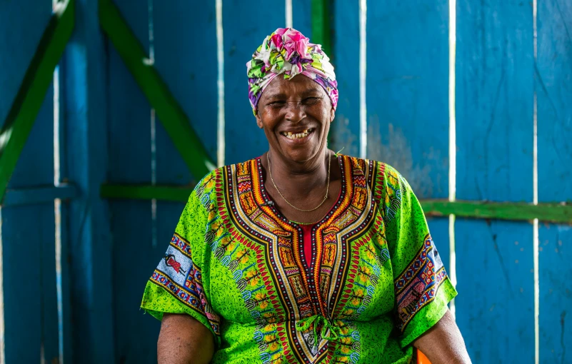 a woman in a brightly colored top smiles at the camera