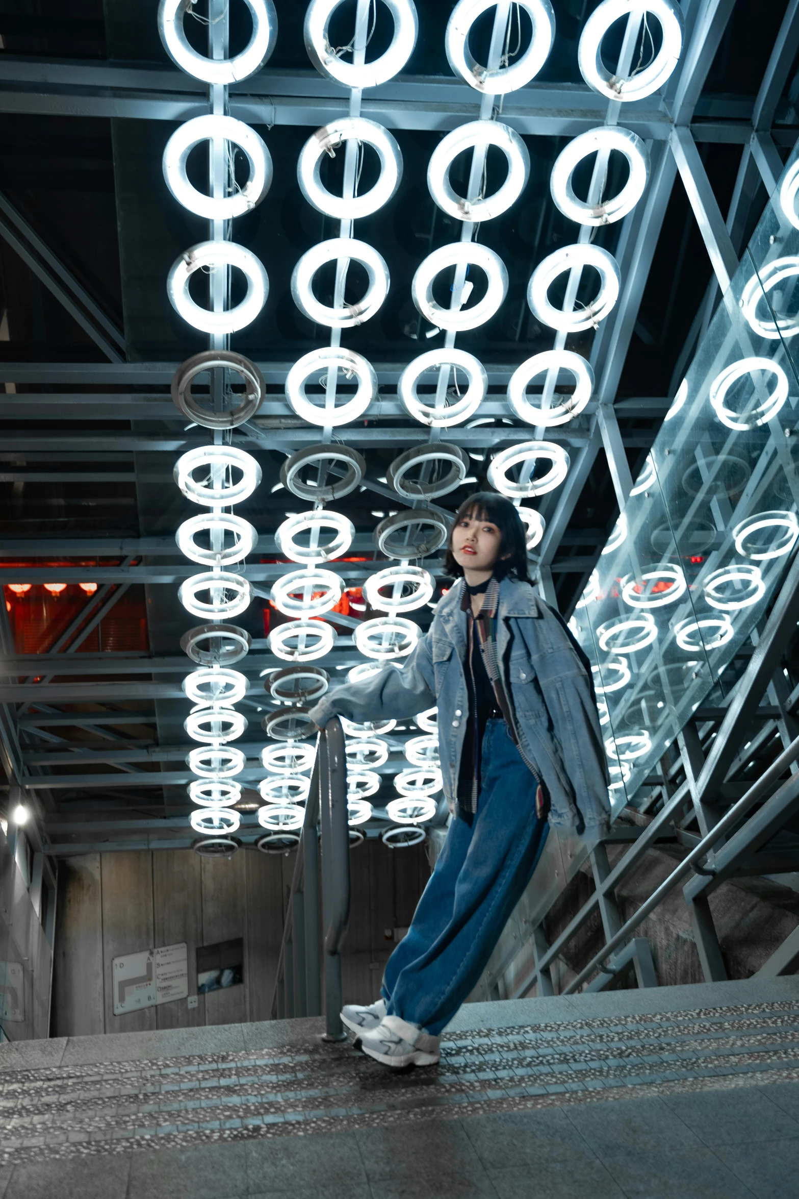 a man standing in a building with lights on the ceiling