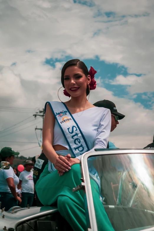 a woman is riding in the back of a vintage car