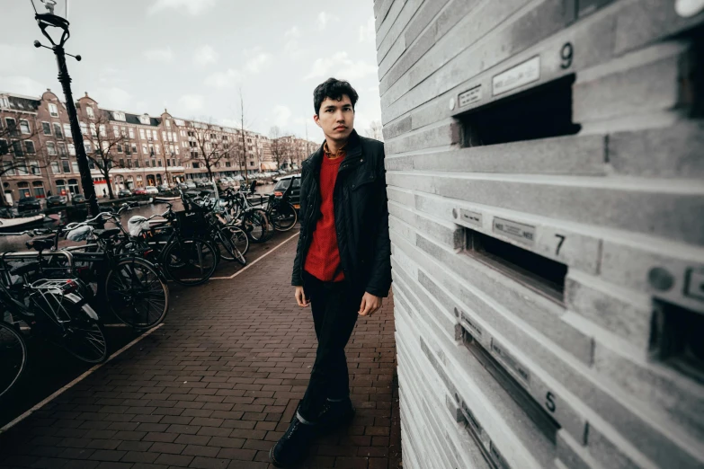 a man standing outside on the sidewalk beside parked bicycles