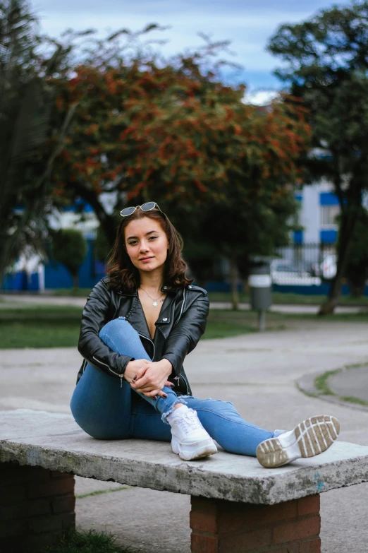 a woman sitting on top of a stone bench