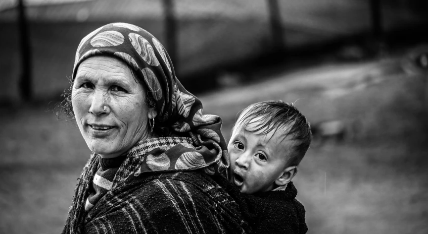 a woman is carrying a small child up in her back