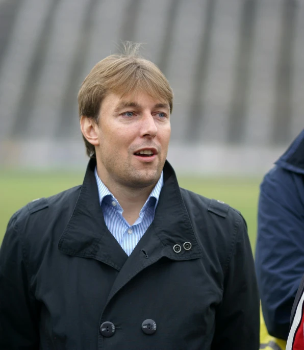 man wearing black coat standing in front of a standstill