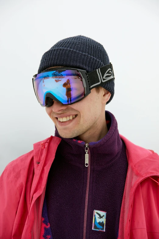 a man in a pink jacket with ski goggles